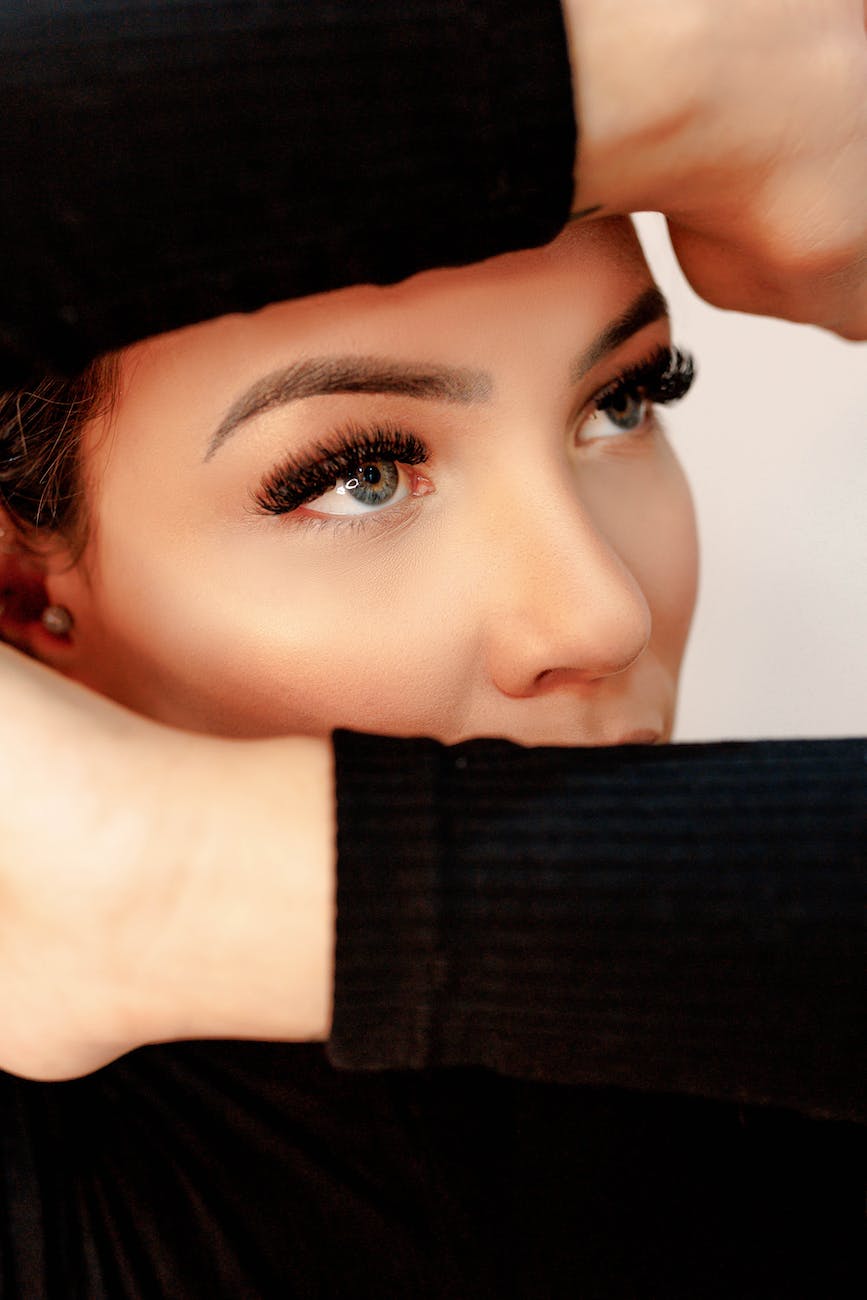 woman holding her arms up and covering half of her face
